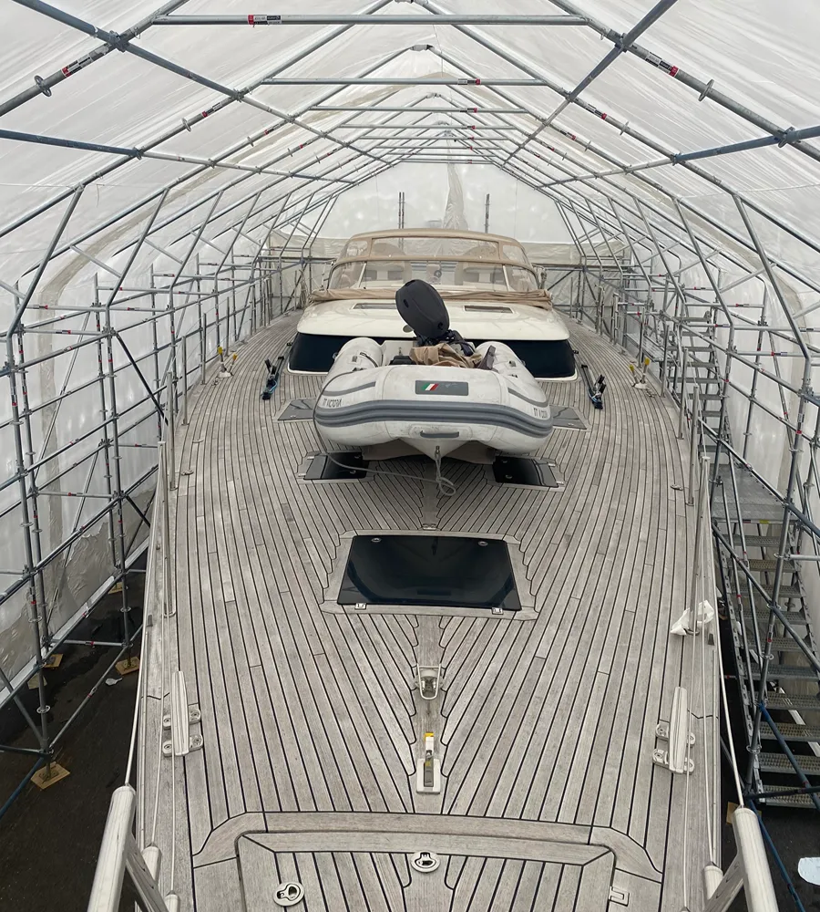 Yacht sheltered inside a temporary scaffold structure with a shrink-wrap roof