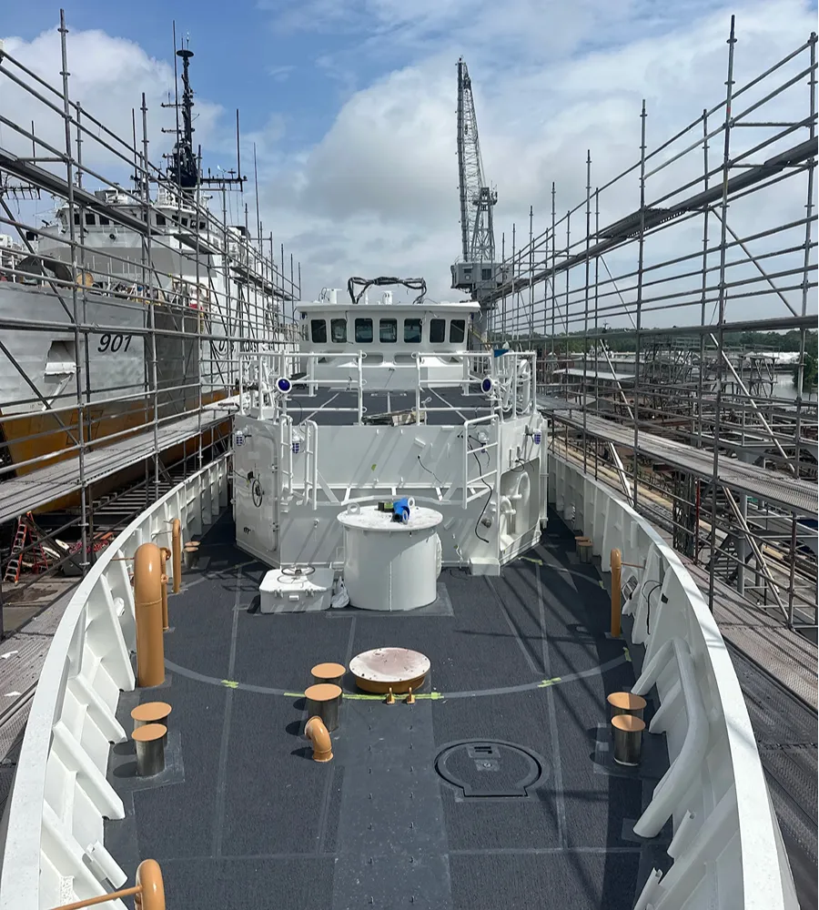 Elevated scaffold walkways with guardrails providing protected access along an active work zone
